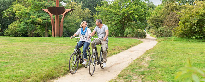 Man en vrouw fietsen in de groene omgeving van Amersfoort